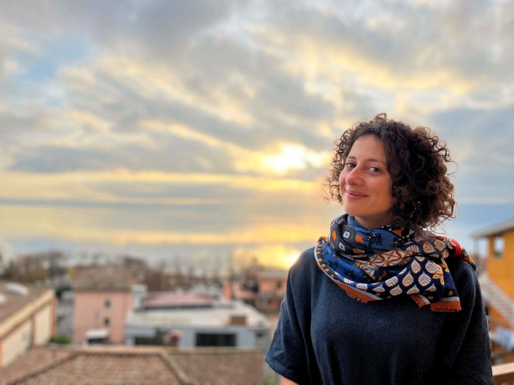 Woman smiling; lake in the background